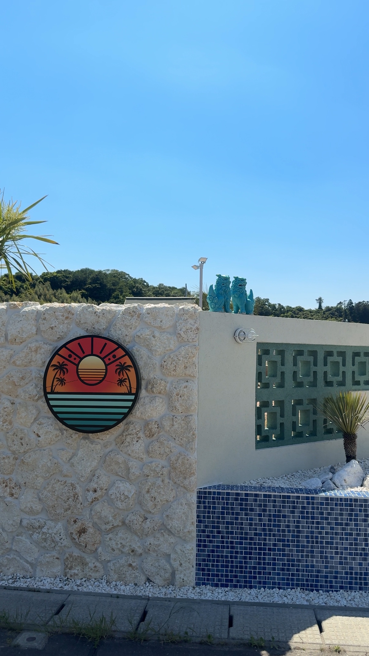 TAIYO sunny villageの外観サインと白い石壁